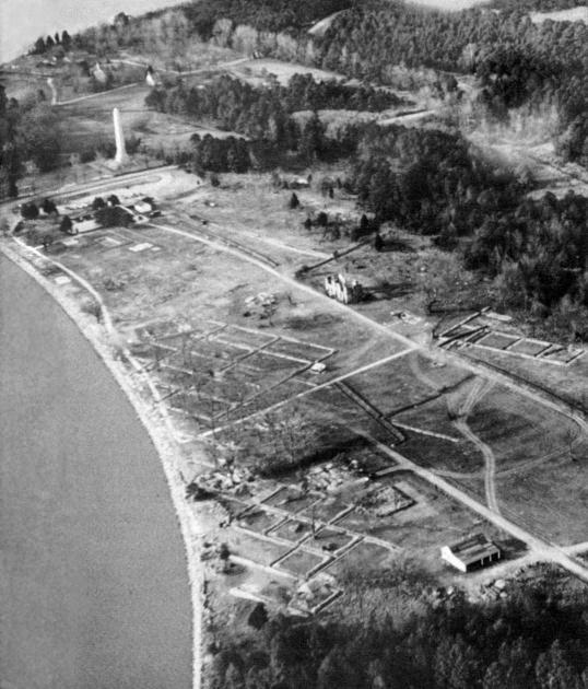 [Illustration: Jamestown exploration trenches of 1955 from the air. Landmarks are the “old cypress” in the river, upper left, the tercentenary monument, and the standing ruin of the 18th-century Ambler house.]